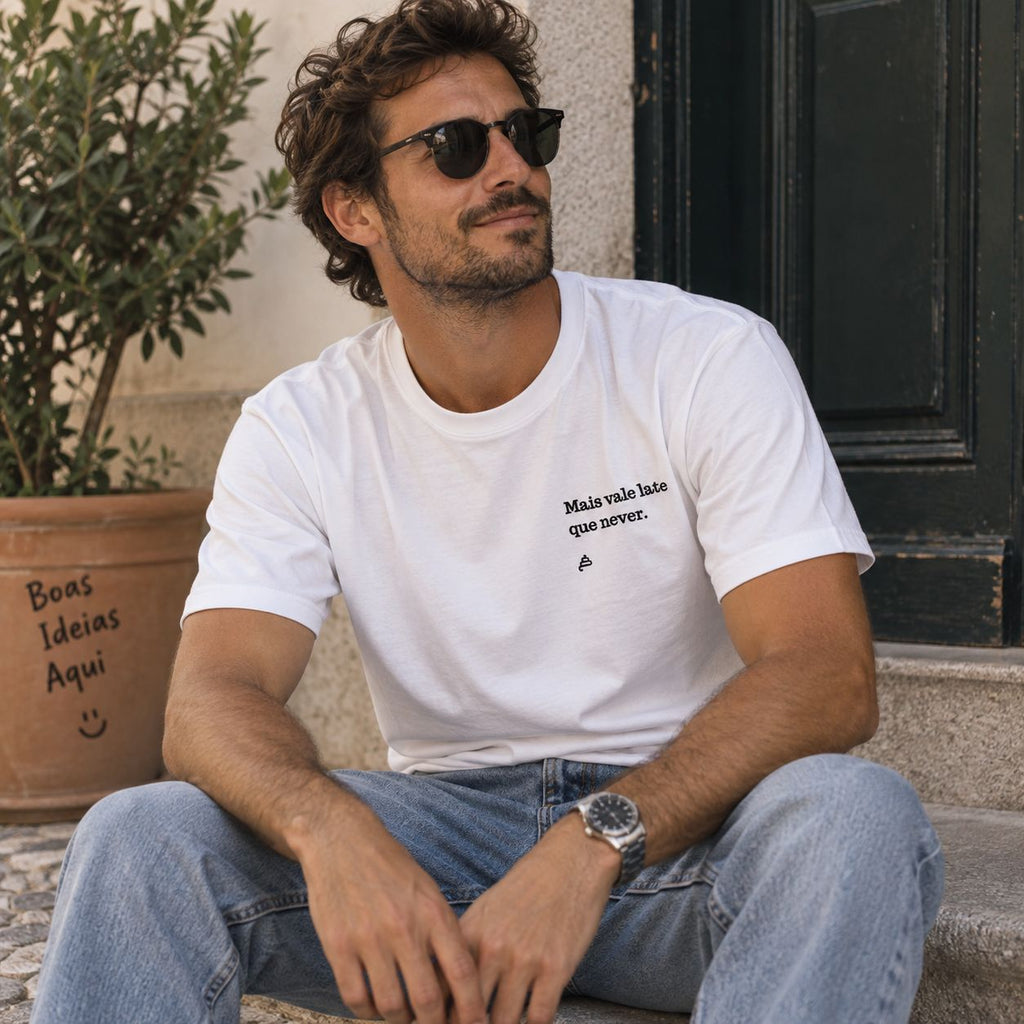 Homem com T-shirt branca bordada com a frase “Mais vale late que never” da Poesia Cocó