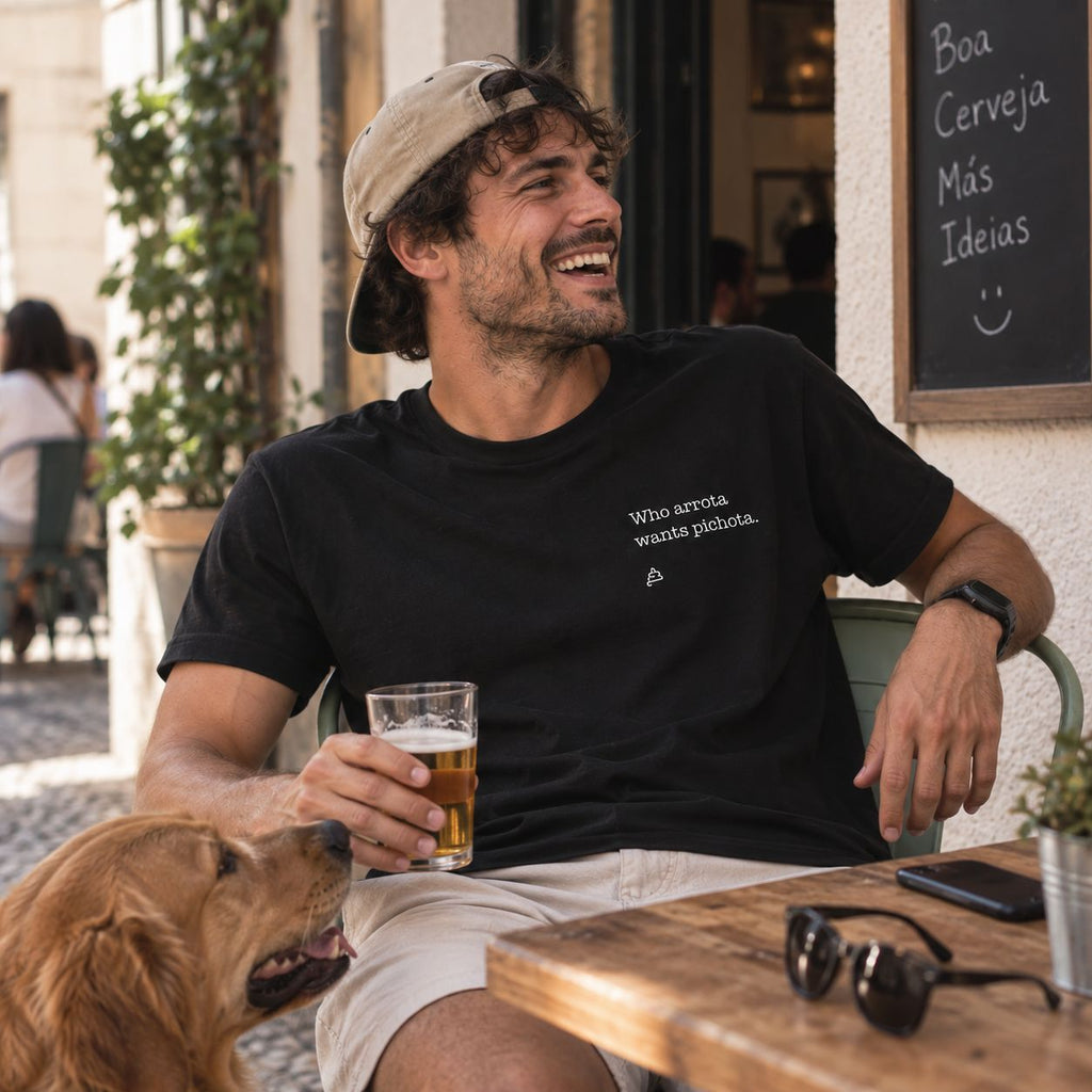 Homem com T-shirt preta bordada com a frase “Who arrota wants pichota” da Poesia Cocó