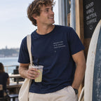 Homem com T-shirt azul bordada com a frase “Quando a life te dá lemons make limonada” da Poesia Cocó
