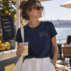 Mulher com T-shirt azul bordada com a frase “Quando a life te dá lemons make limonada” da Poesia Cocó