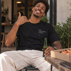 Homem com T-shirt preta bordada com a frase “Who ri por último, ri better” da Poesia Cocó