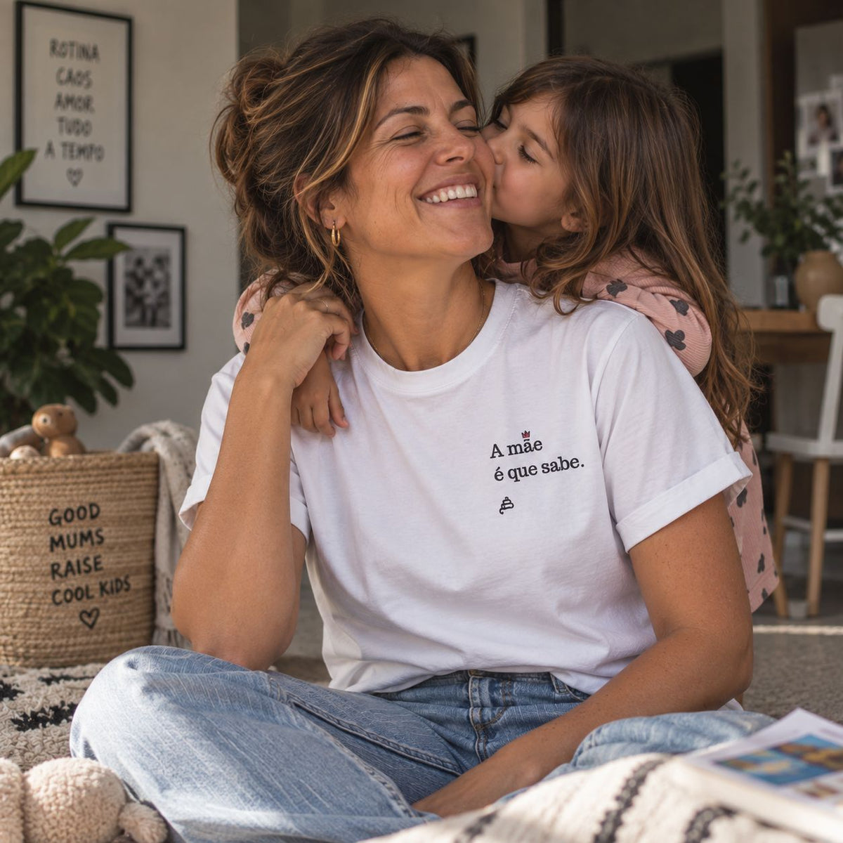 Mãe com T-shirt branca bordada com a frase “A mãe é que sabe” da Poesia Cocó, acompanhada pela filha