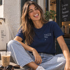 Mulher com T-shirt azul bordada com a frase “In land of cego quem tem olho é king” da Poesia Cocó