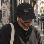 Homem com boné preto bordado “O que não te kill makes you mais forte.” da Poesia Cocó