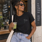 Mulher com T-shirt preta bordada com a frase “Quem não arrisca, don’t snack” da Poesia Cocó